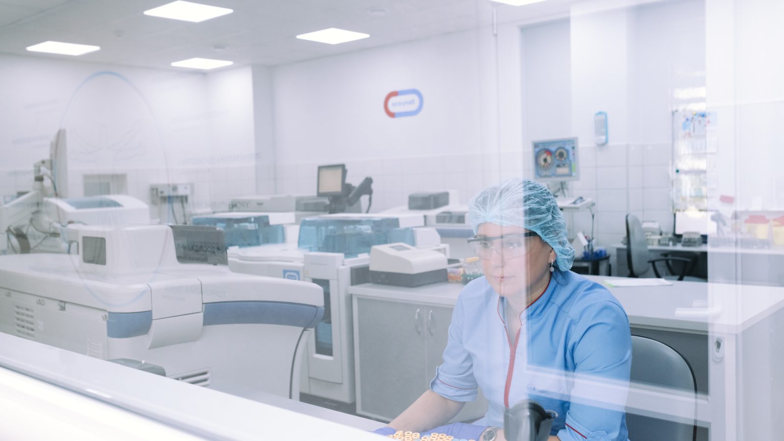 Alat analisis laboratorium dan seorang teknisi di laboratorium klinik